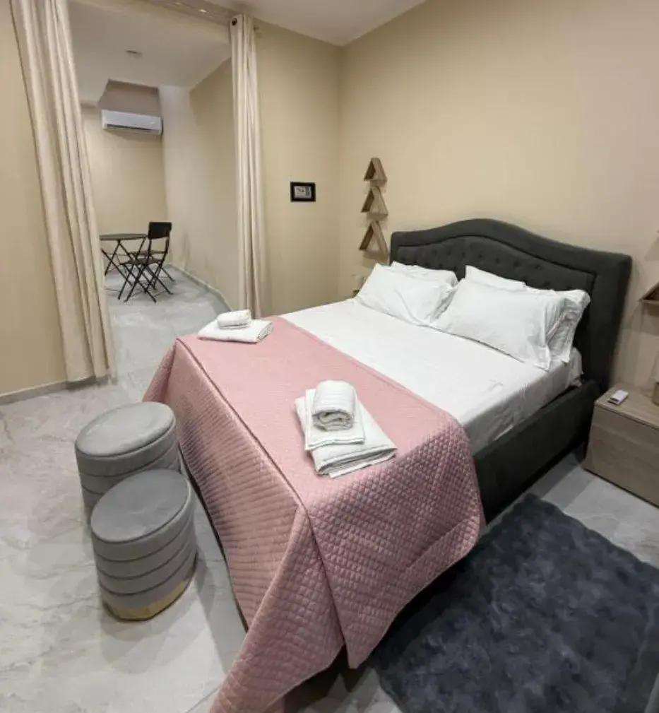 Camera con letto matrimoniale e tavolo con sedie nell'appartamento