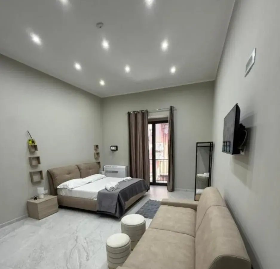 Camera Quadrupla Comfort da 25 m² con divano e balcone