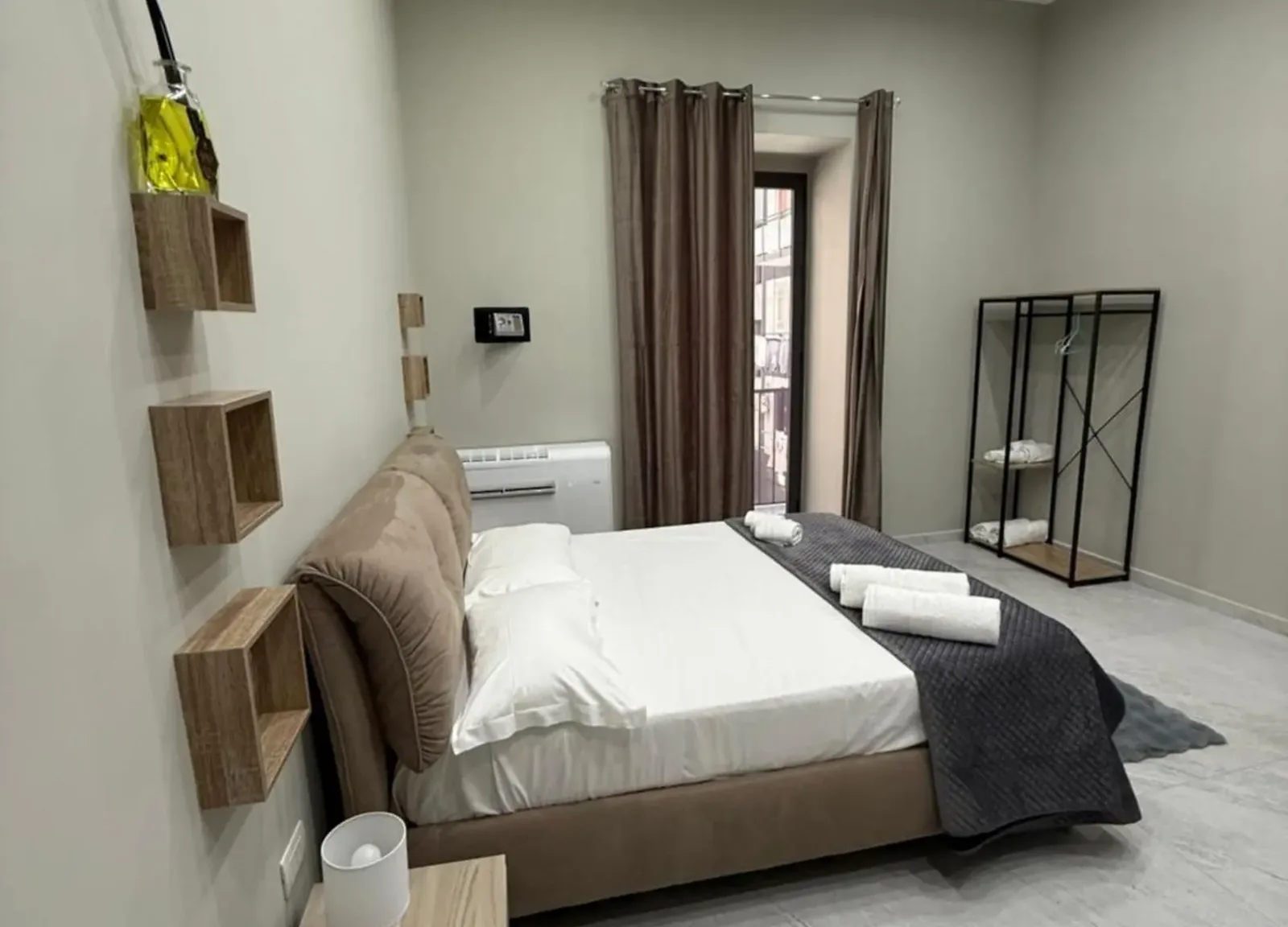 Letto matrimoniale con testiera imbottita e appendiabiti aperto