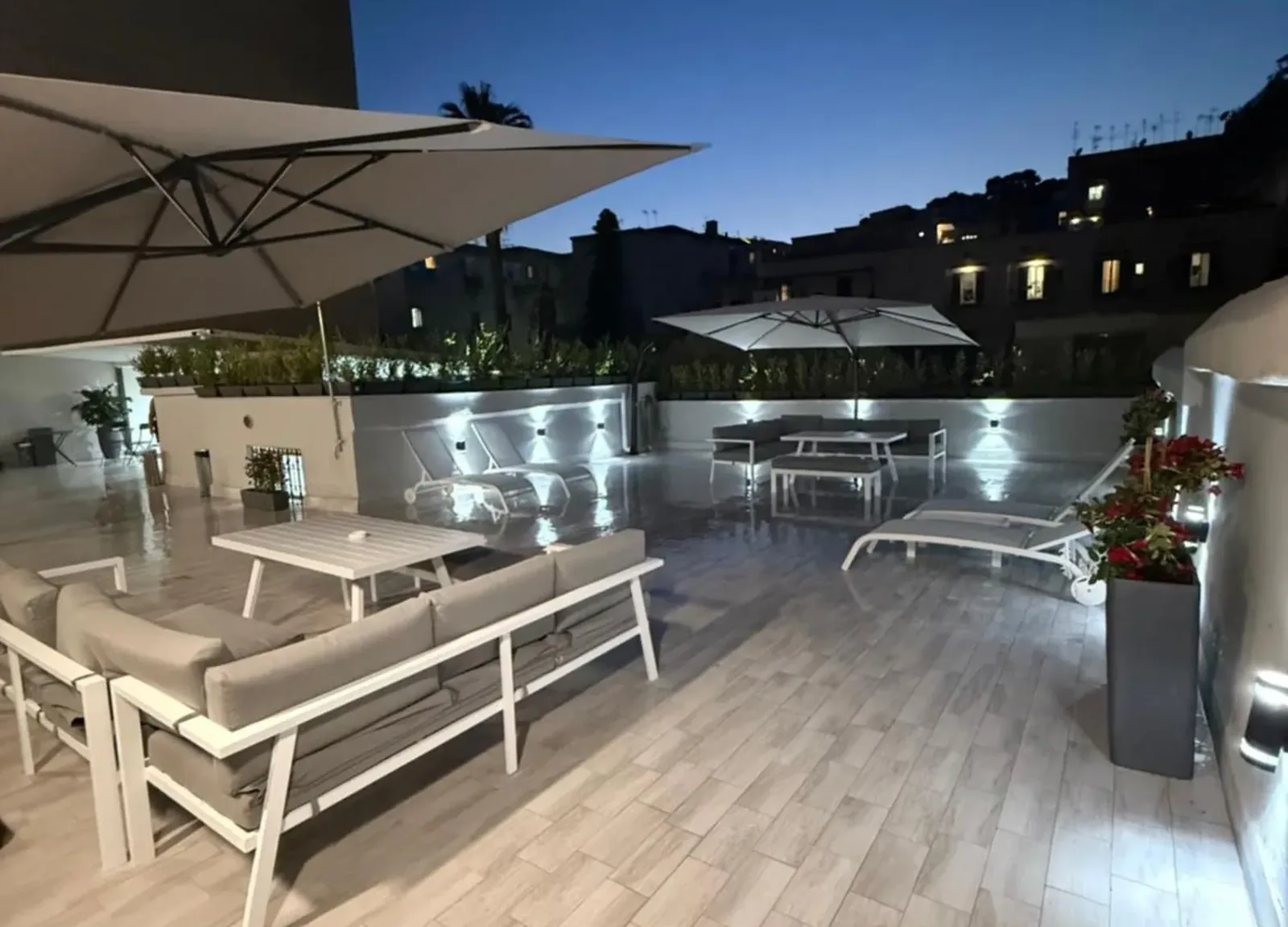 Terrazza del Palazzo Valentino al tramonto con divani e lettini