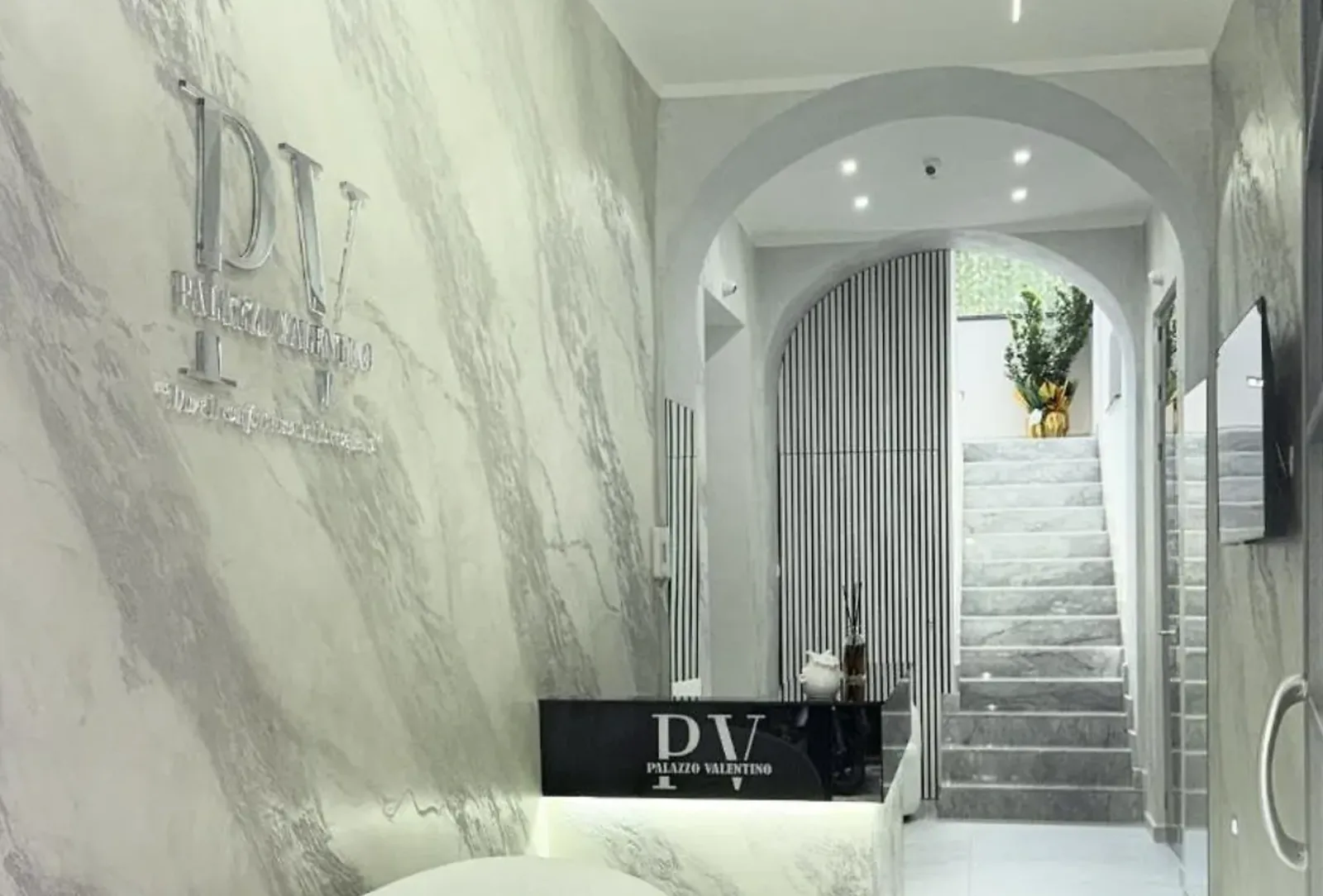 Reception con il logo di Palazzo Valentino e scala in marmo